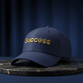 Success embroidered baseball cap in navy with gold embroidery